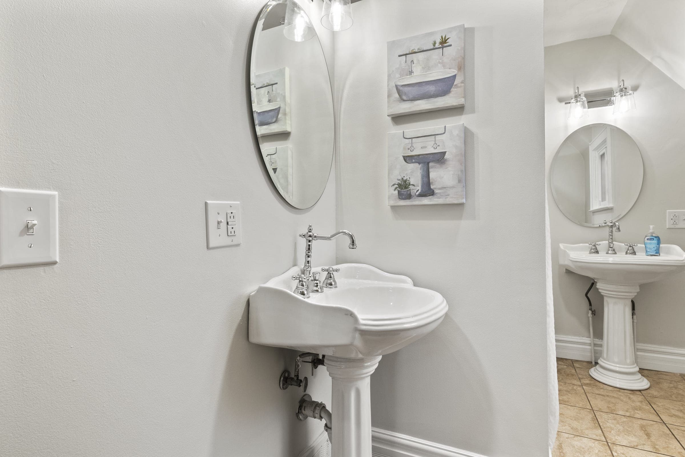 Bathroom with a pedestal sink and round mirror