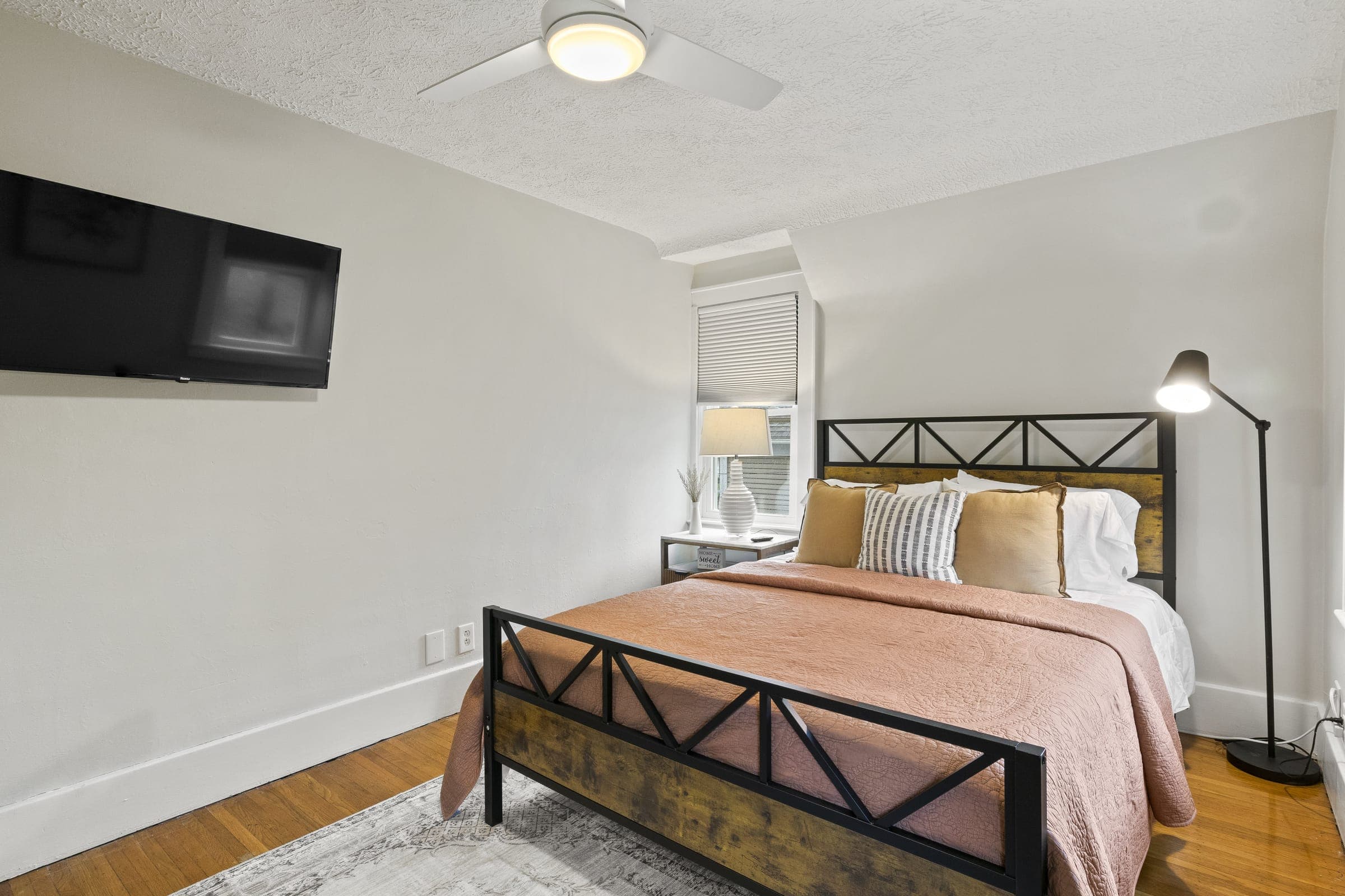 Bedroom with an iron bed frame and terracotta bedding