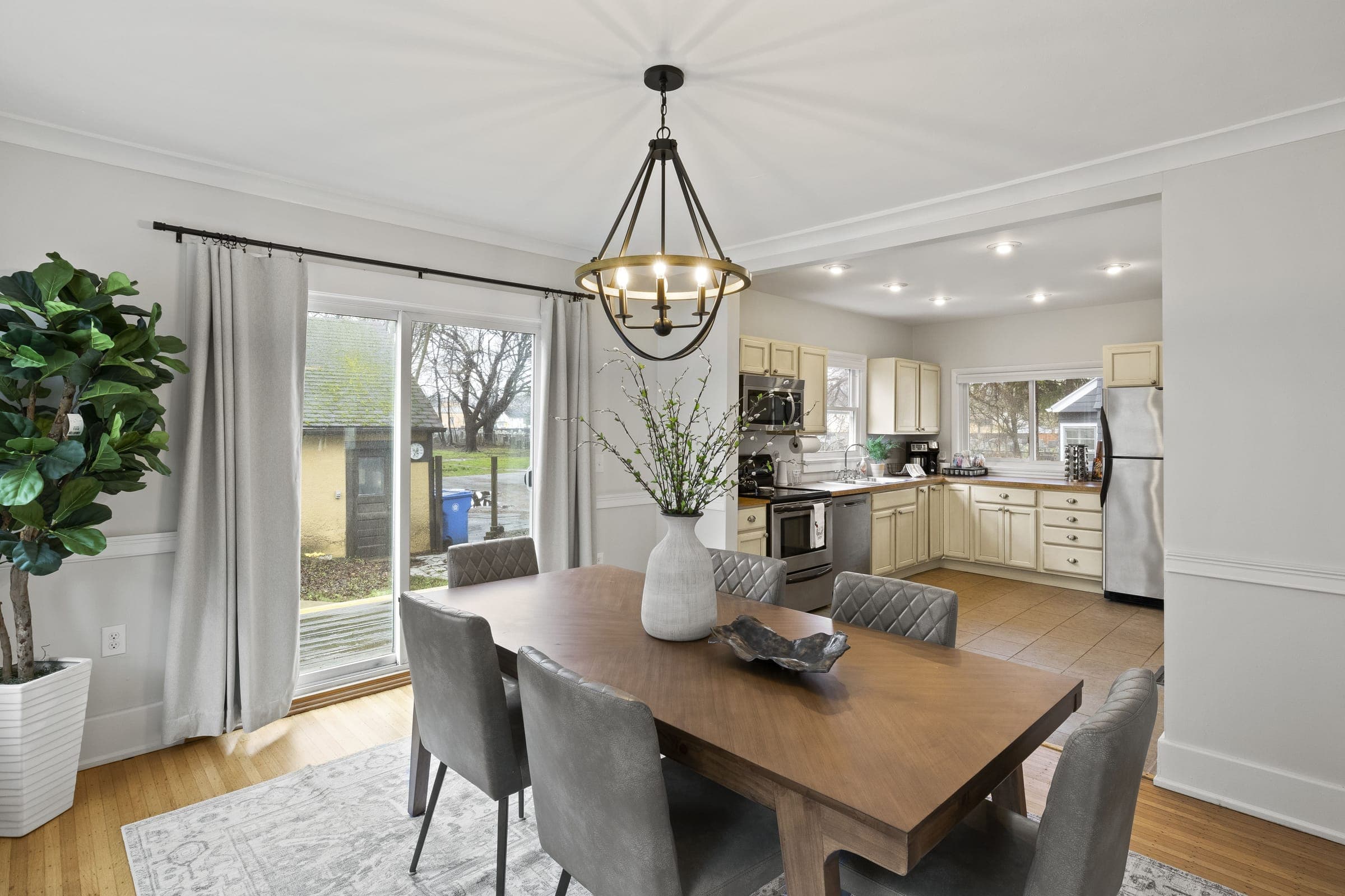 Dining table for six under a pendant light, with sliding doors to the yard